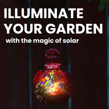 A glowing red glass hummingbird feeder lit by its built-in solar-powered LED light, enhancing garden ambiance.